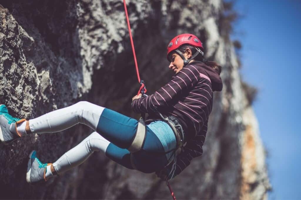 person abseiling on rock face