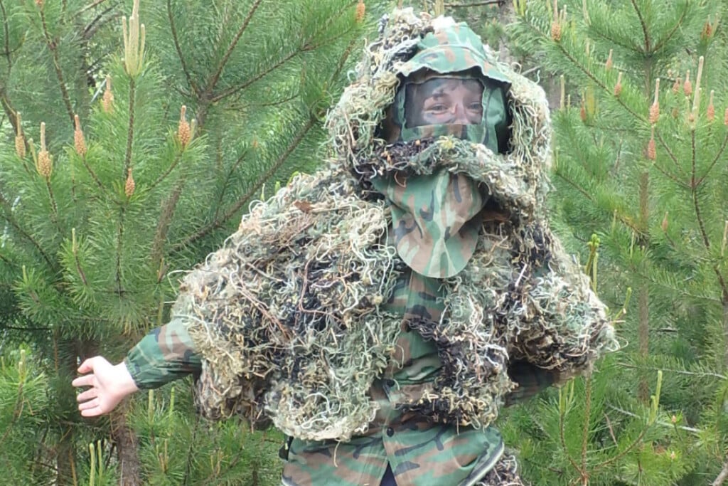 person in camouflage gear as part of bushcraft manhunt exercise
