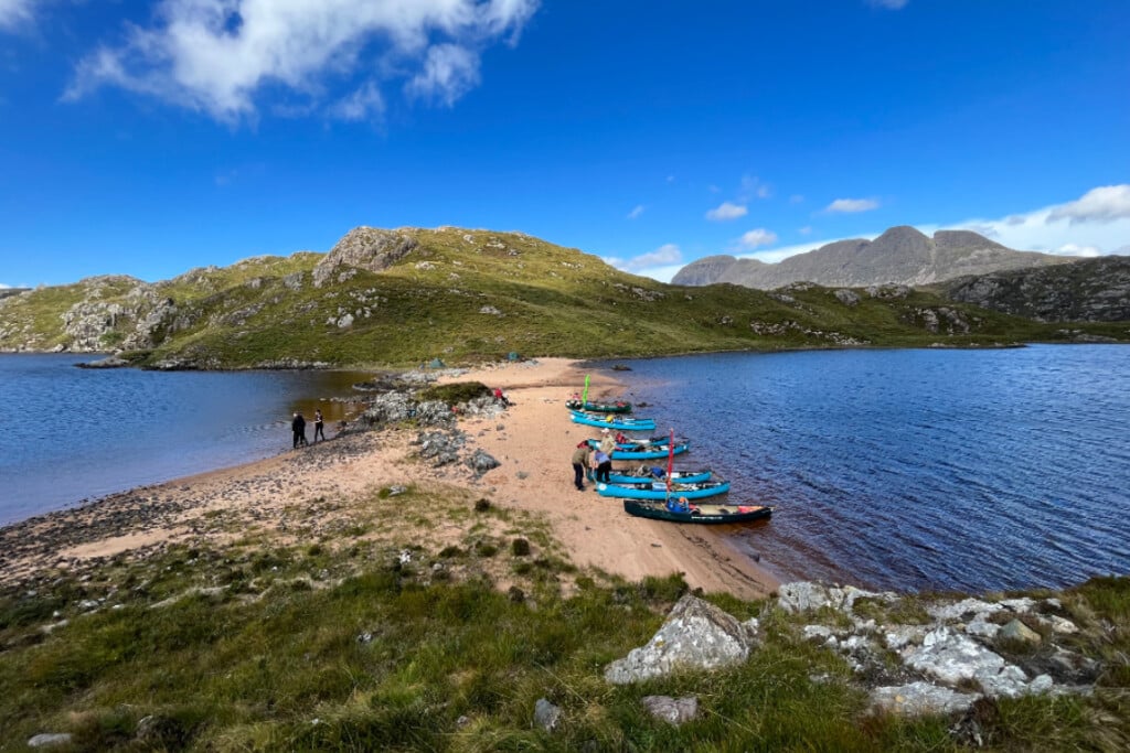canoes landed on a beach between lochs in the inverpolly/ assynt area of scotland. Suilven mountain in the background