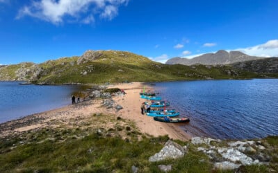 canoes landed on a beach between lochs in the inverpolly/ assynt area of scotland. Suilven mountain in the background