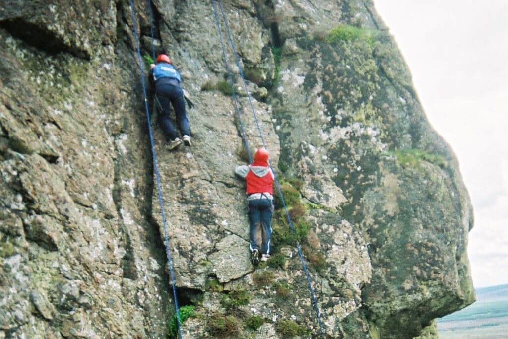 2 people rock climbing on a rock face