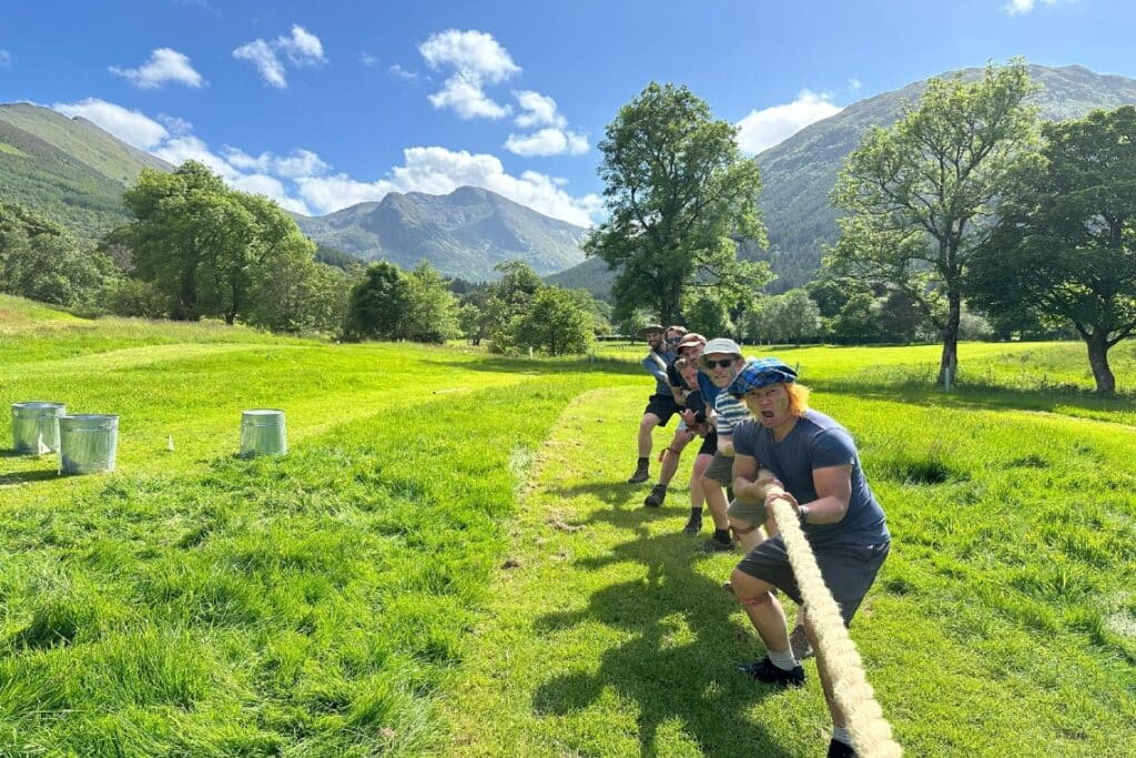 Highland Games Glencoe - group of men doing tug of war with mountainous, green background