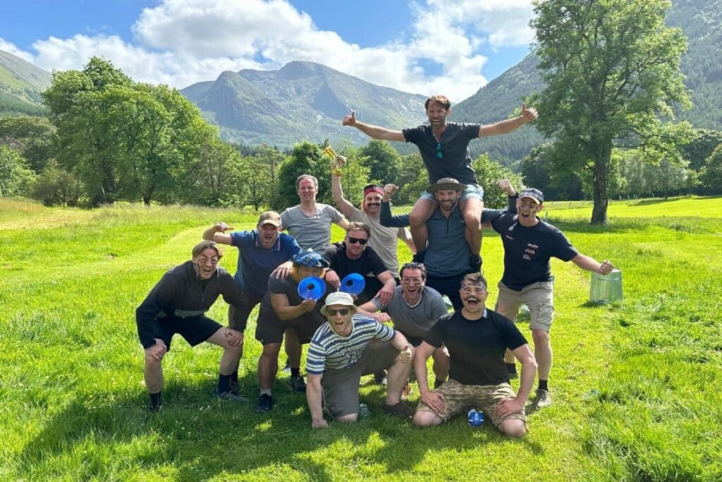 Highland Games Glencoe - group of men pose for a photo with mountainous, green background