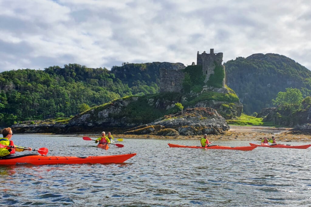 sea kayaking past castle tioram, loch moidart