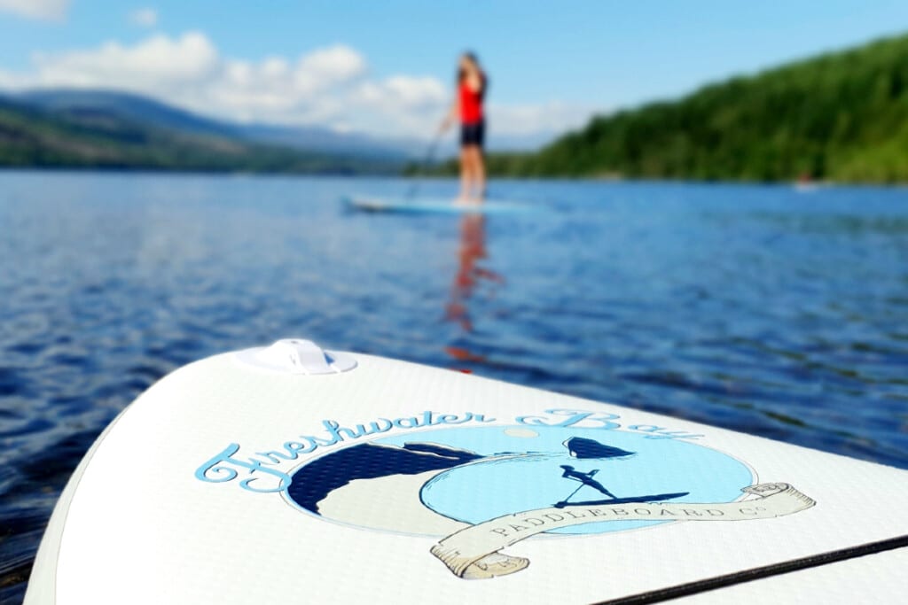 photo of someone paddle boarding with SUP deck in foreground