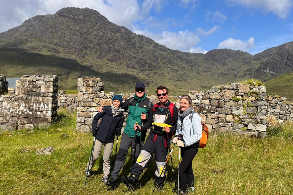 group photo with ruined croft and mountains in the background