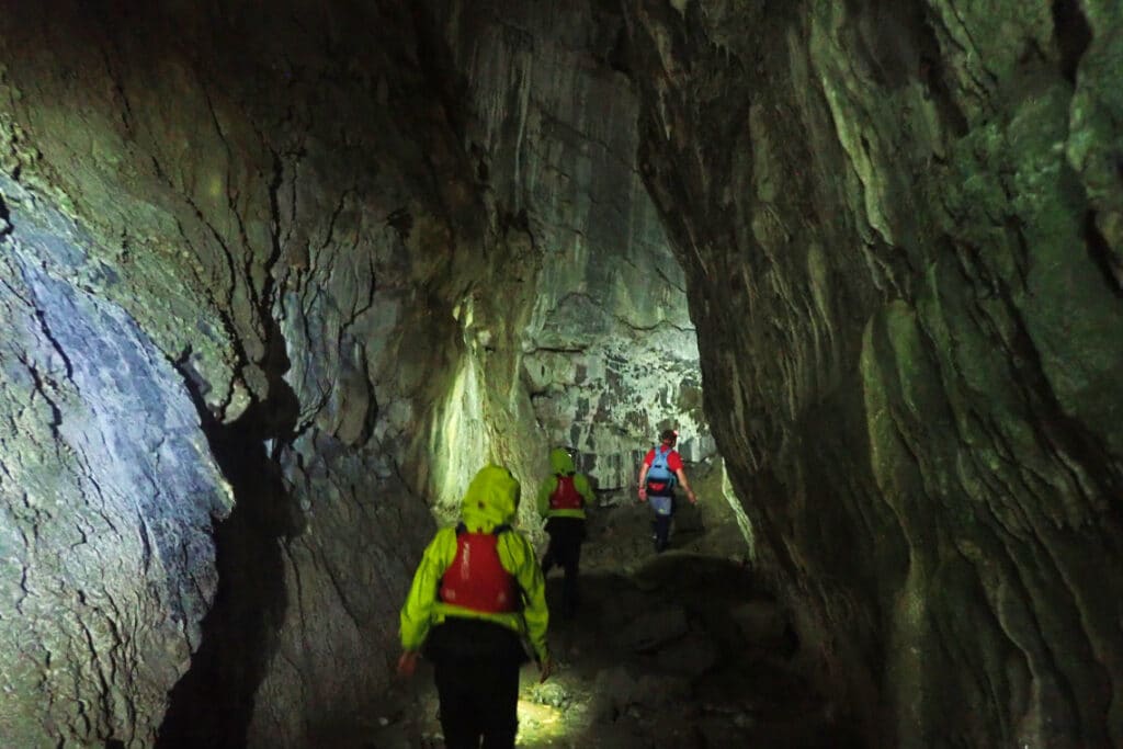 exploring spar cave on isle of skye, with head torches lighting the way