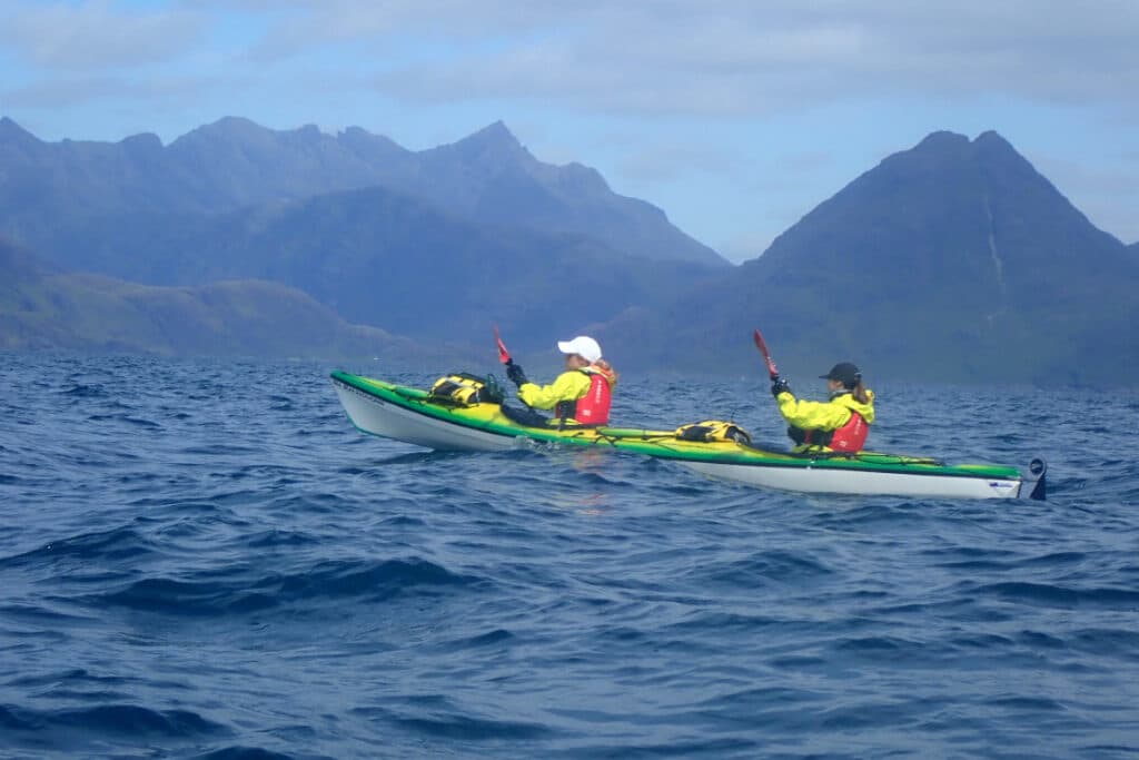 tandem kayak with cuillin mountains of skye as a backdrop