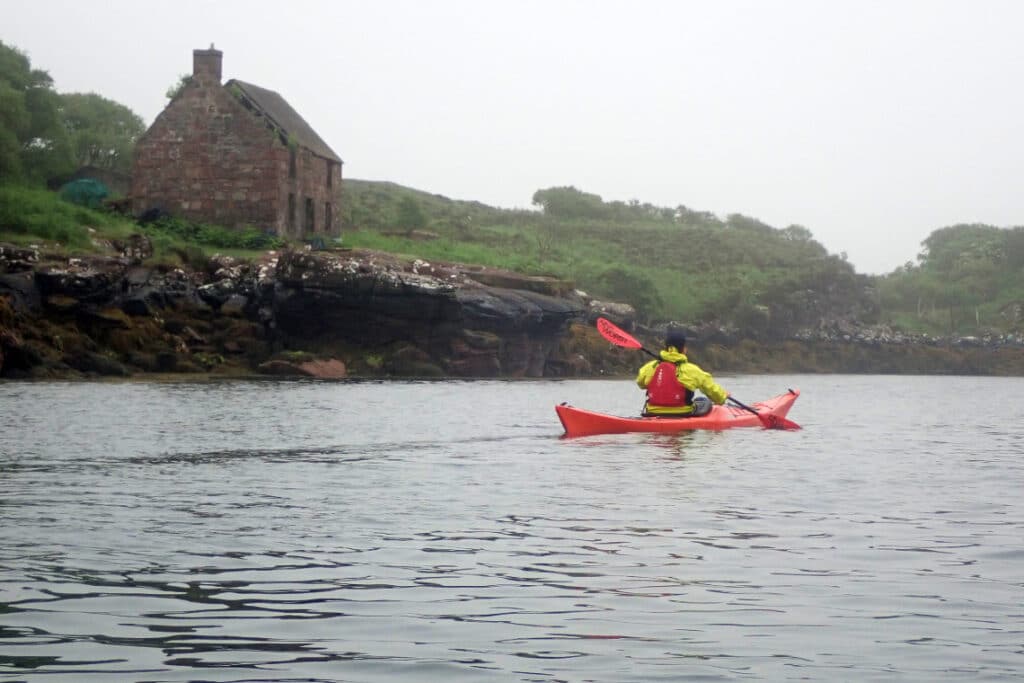 kayak paddles by an old whaling station on the island of soay, skye