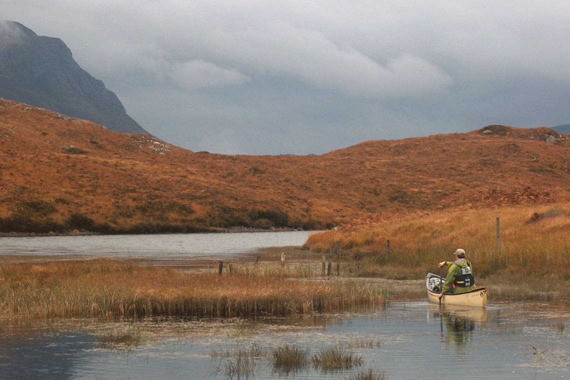 lone canoeist on a remote loch in north west scotland