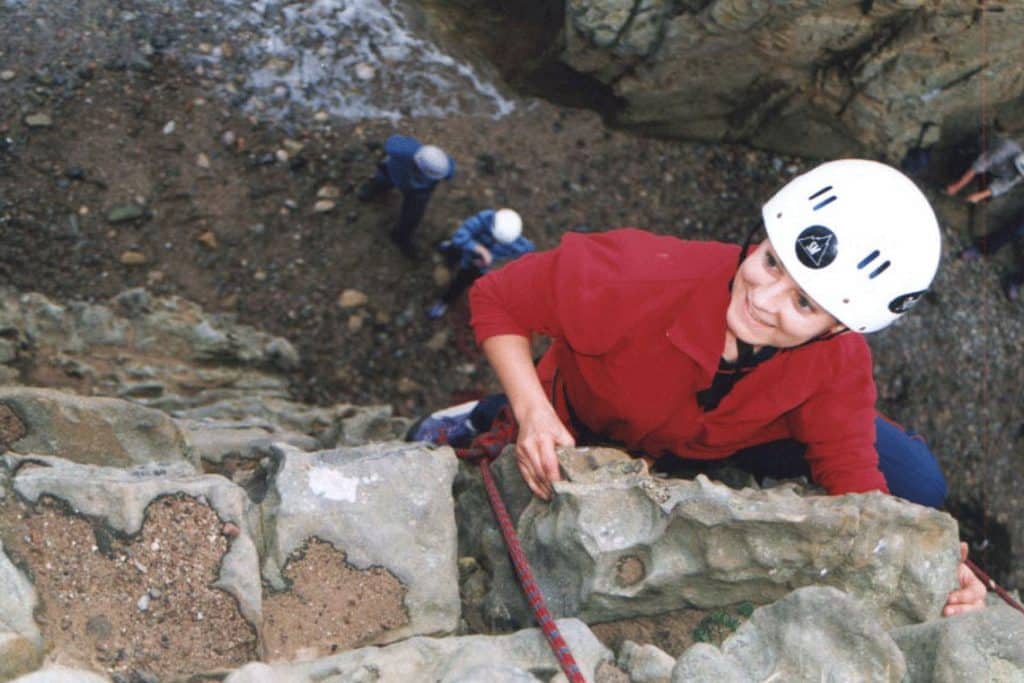 person smiling as they rock climb