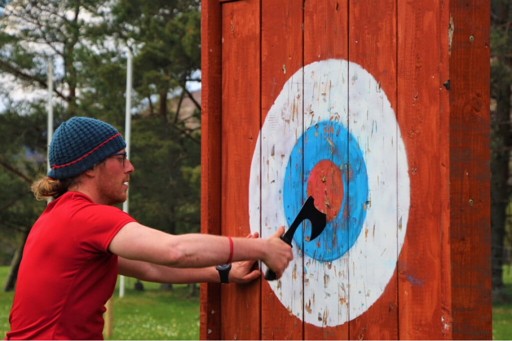 person pulling axe from axe throwing target.